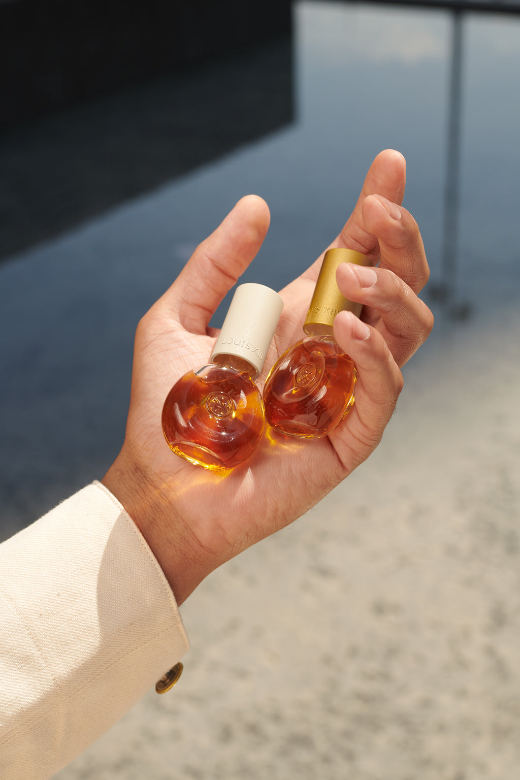 A lifestyle photo of a hand holding two DROP bottles