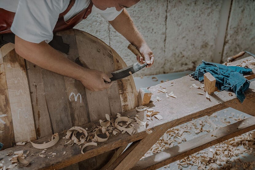 A photo of a man making a barrel with his tools