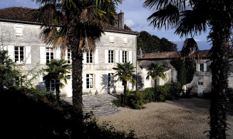 A photo of a white house entry, with palms