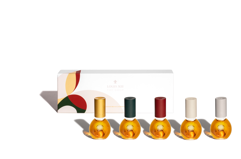 A packshot of five DROP bottles in a row, a package behind, all on a white background