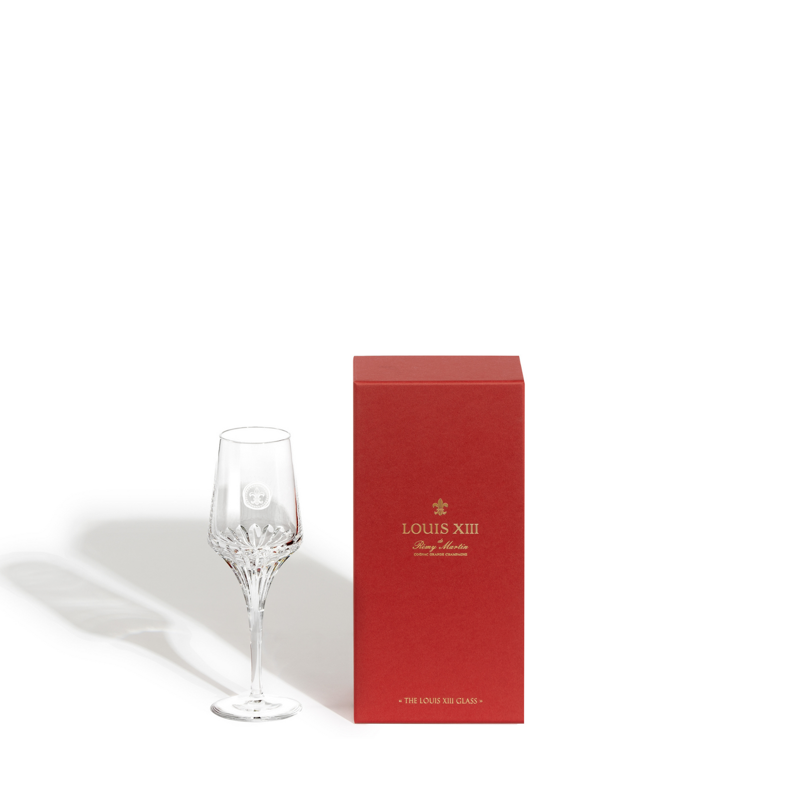 A packshot of a LOUIS XIII single crystal glass with its red packaging